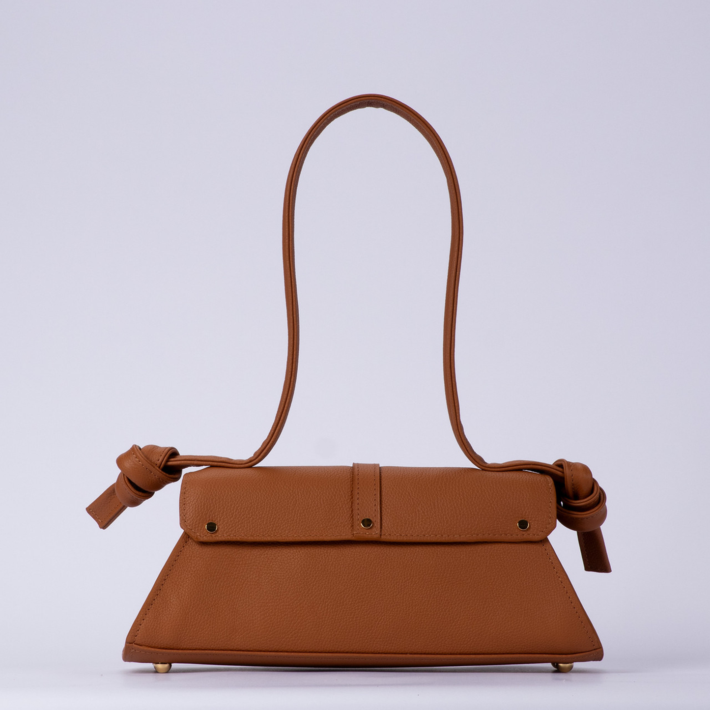 Warm Sienna Tan Trapezoid Elongated Shoulder Bag With Hand-Tied Knot Handle Ends, Curved Overlap Flap And Base Protective Metal Feet