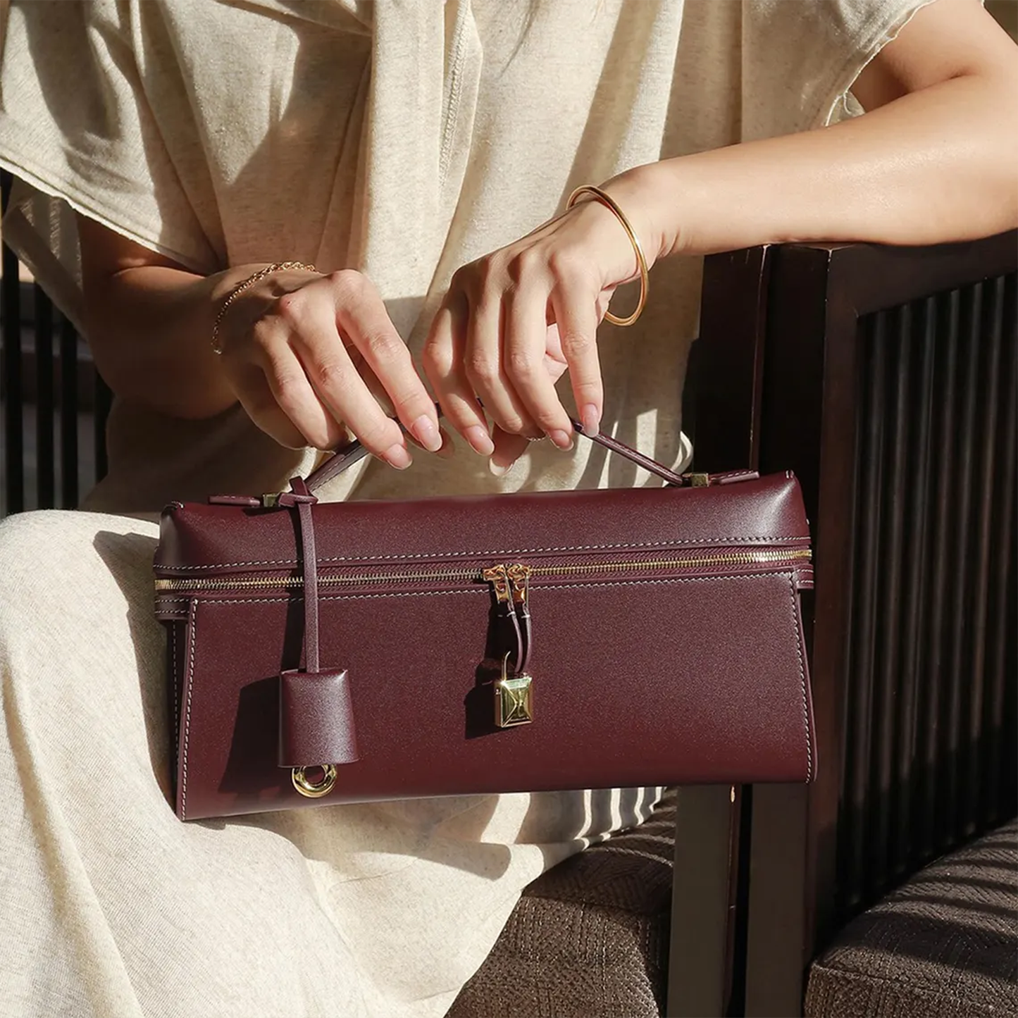 Rich Burgundy Elongated Rectangular Hand Pouch With Contrast Edge Stitching, Golden Dual Zipper Sliders And Slim Curved Top Carry Handle