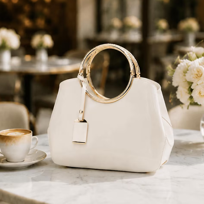 Cream Off-White Polished Trapezoid Carryall With Layered Embossed Golden Circular Hoop Handles, Metallic Trimmed Hanging Tag And Spacious Rounded Inner Compartment