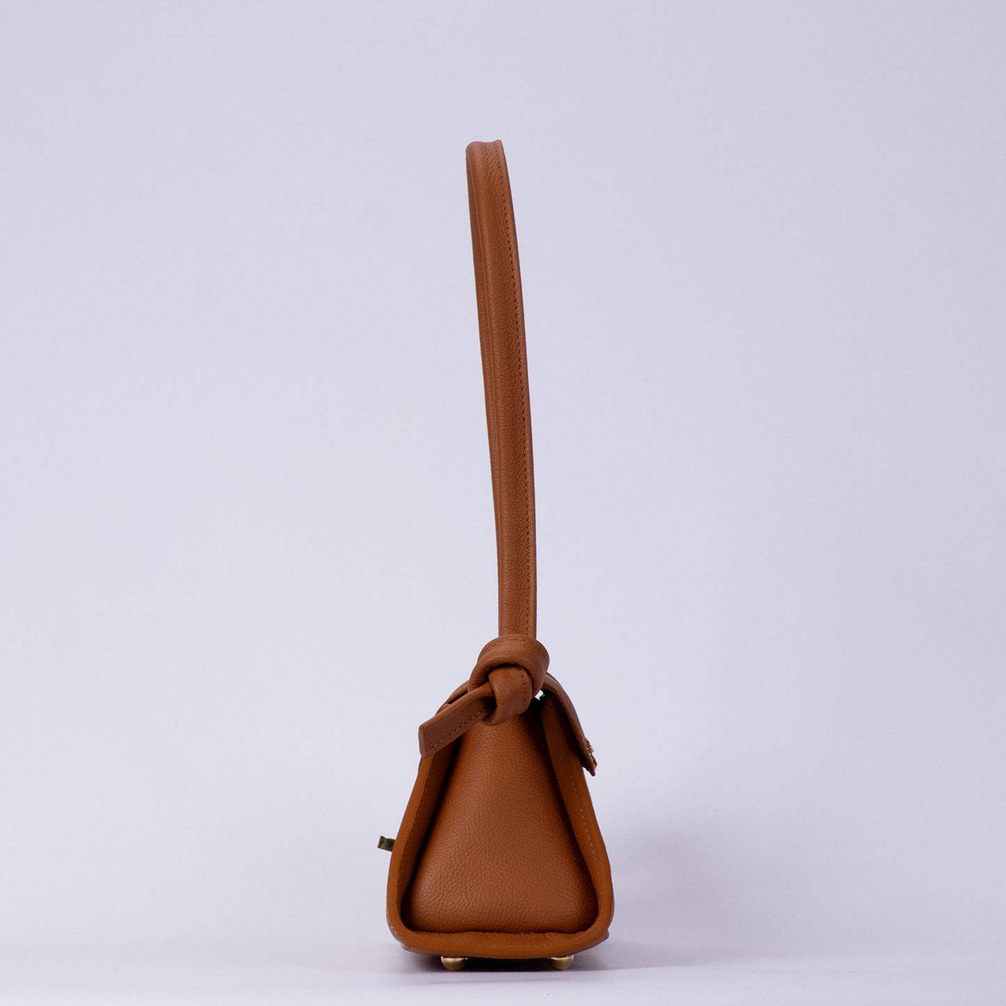 Warm Sienna Tan Trapezoid Elongated Shoulder Bag With Hand-Tied Knot Handle Ends, Curved Overlap Flap And Base Protective Metal Feet