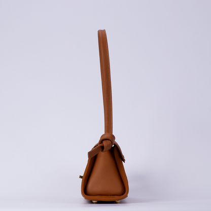 Warm Sienna Tan Trapezoid Elongated Shoulder Bag With Hand-Tied Knot Handle Ends, Curved Overlap Flap And Base Protective Metal Feet