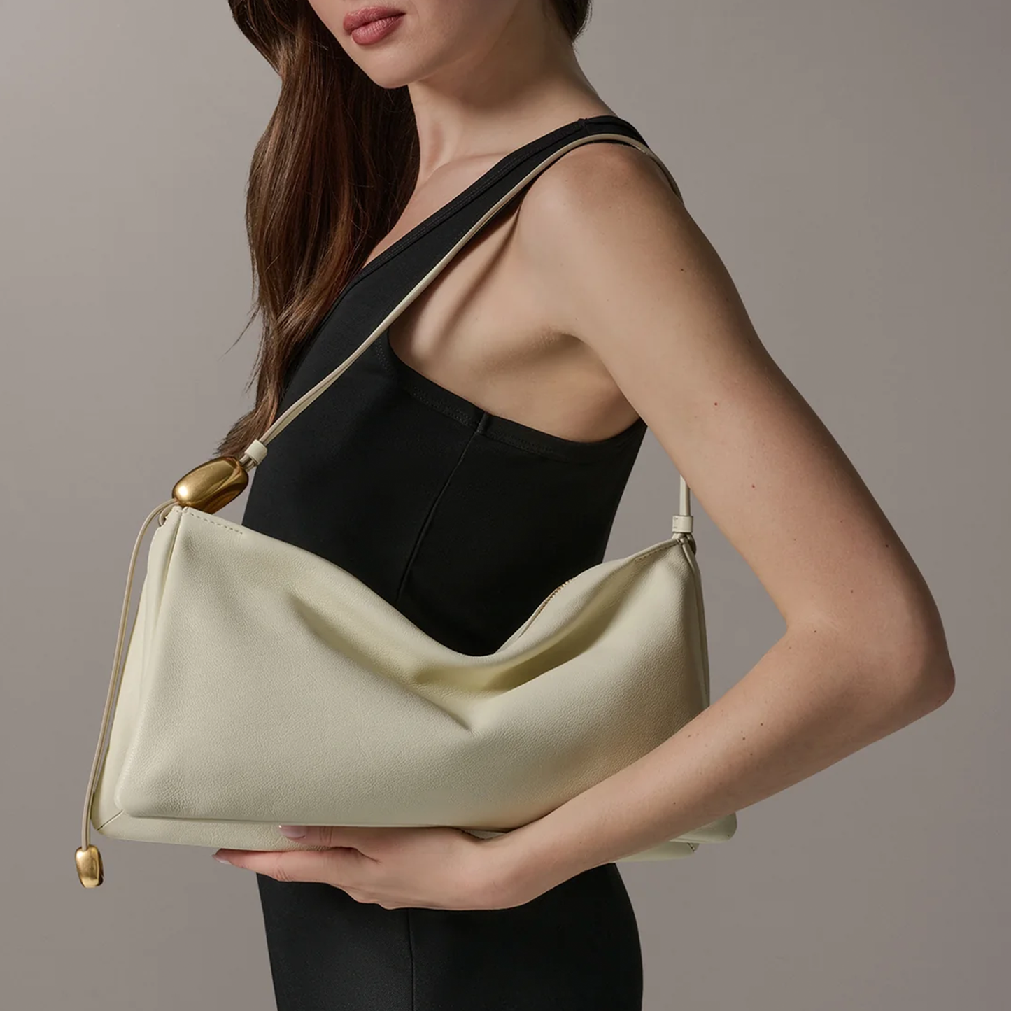 Creamy Ivory Draped Crescent Shoulder Bag With Slim Single Shoulder Strap, Pebble Shaped Gold Metallic Accents And Curved Central Dip Silhouette