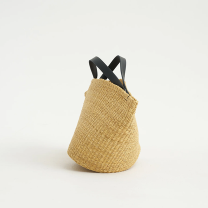 Natural Straw Asymmetrical Pinched Fan Shaped Tote With Smooth Curved Overhead Grip Strips, Wide Open Unsegmented Cavity And Soft Folded Base Silhouette