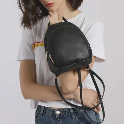 Solid Matte Black Curved Dome Mini Backpack With Dual Gold Tone Zipper Pulls, Short Curved Top Grip And Thin Metal Fitted Rear Support Straps